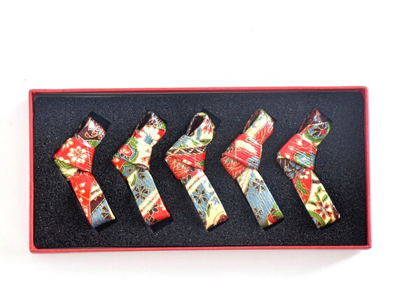 Washi paper chopstick rests set arranged neatly inside the foam insert of a red presentation box
