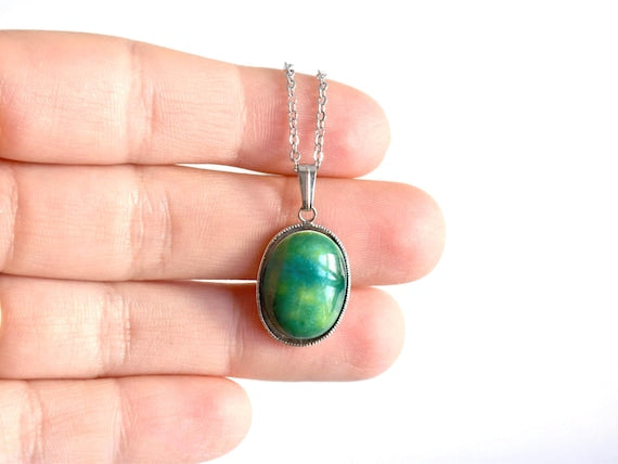 Green Oval Kutani pendant necklace displayed across a hand to show size