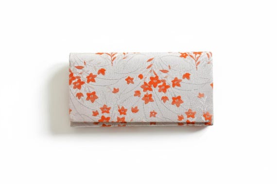 Kimono clutch evening bag shown fully open, revealing the structured accordion style interior compartments