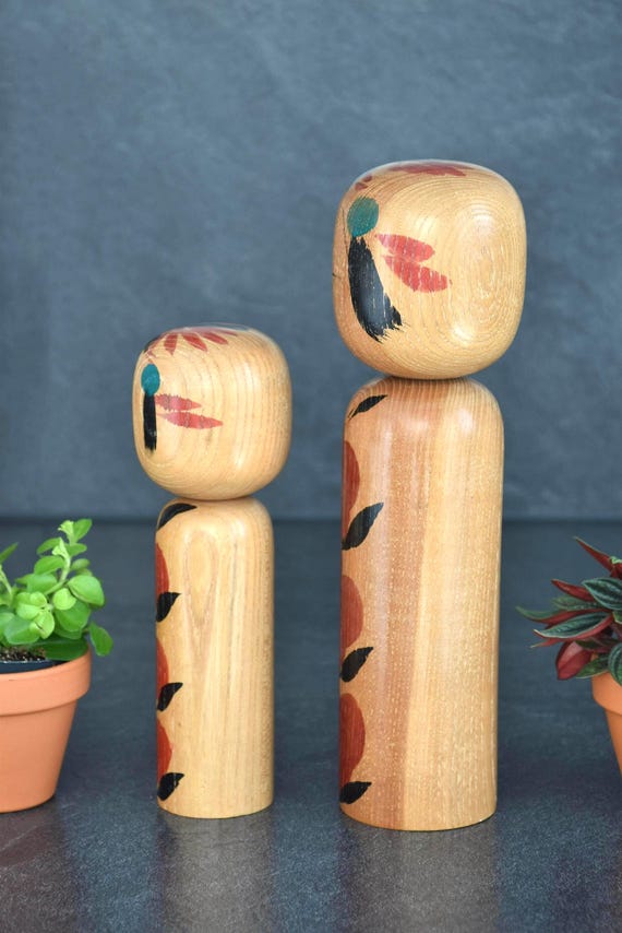 Takahashi Hashime kokeshi pair vertical composition featuring both small and large handmade dolls