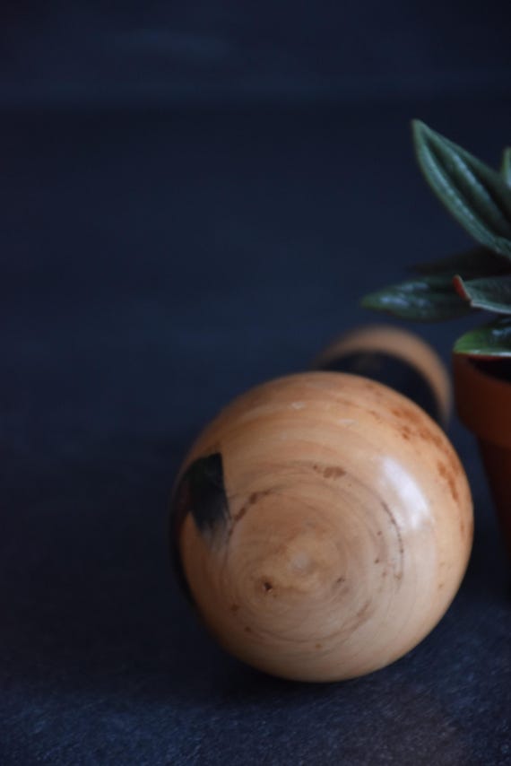 Vintage Japanese kokeshi doll with poem showing the top of the wooden head with grain pattern.