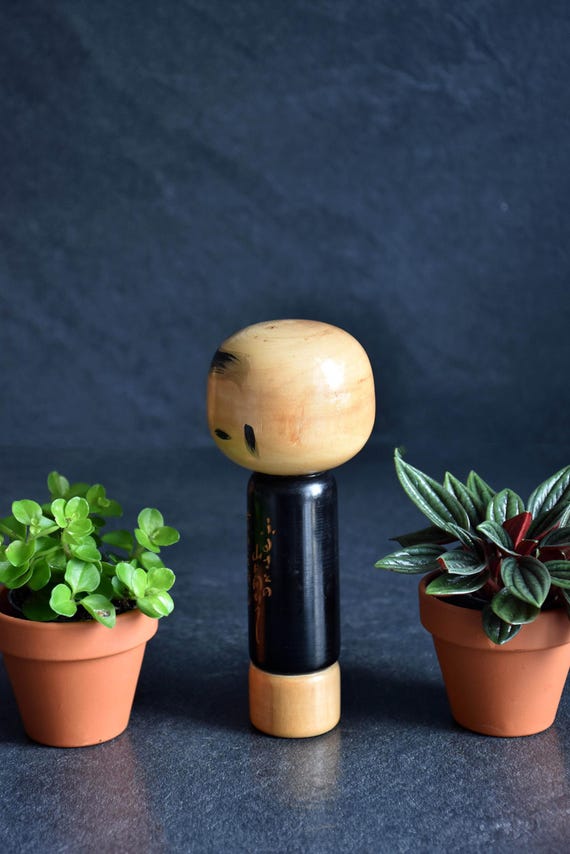 Vintage Japanese kokeshi doll with poem showing the side profile and natural wood grain.