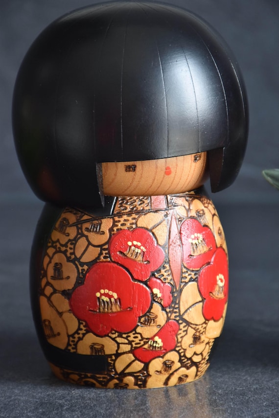 Kazuo Takamizawa creative kokeshi doll close up of wood incised red and harvest orange kimono