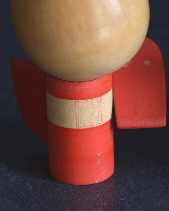 Sansaku Sekiguchi red kokeshi doll back showing the maker stamp on the body