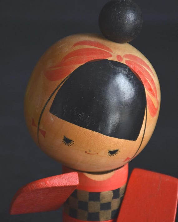 Sansaku Sekiguchi red kokeshi doll face detail with minimalist features