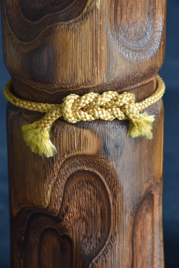 Usaburo Mori Kan Kokeshi Doll showing the simple yellow braided cord tied obi