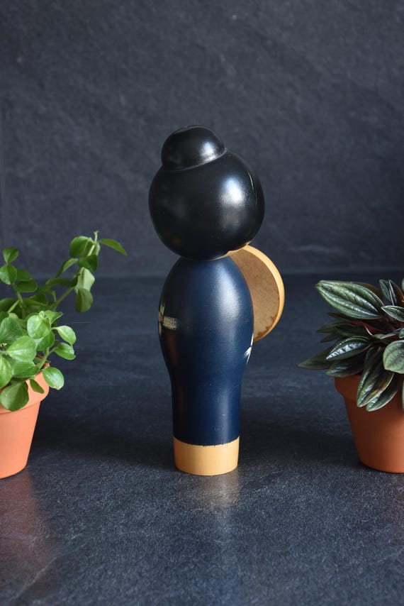 Miyashita Hajime kokeshi doll viewed from the back, highlighting the smooth black updo hairstyle