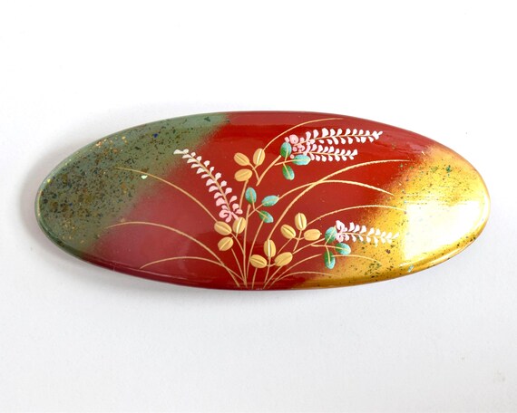 Maki-E Red Oval Barrette With Gold Floral isolated on white background showing the entire top surface