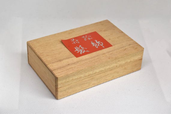 Maki-E Red Oval Barrette With Gold Floral inside its closed original paulownia wood presentation box