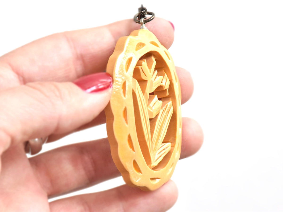 Oyama tsuge wood tulip pendant necklace profile view held in hand showing the wooden depth
