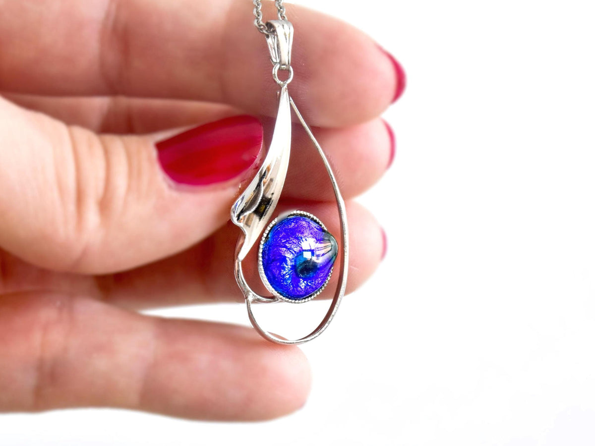 Japanese Oval Blue Pendant Necklace held next to a hand for size