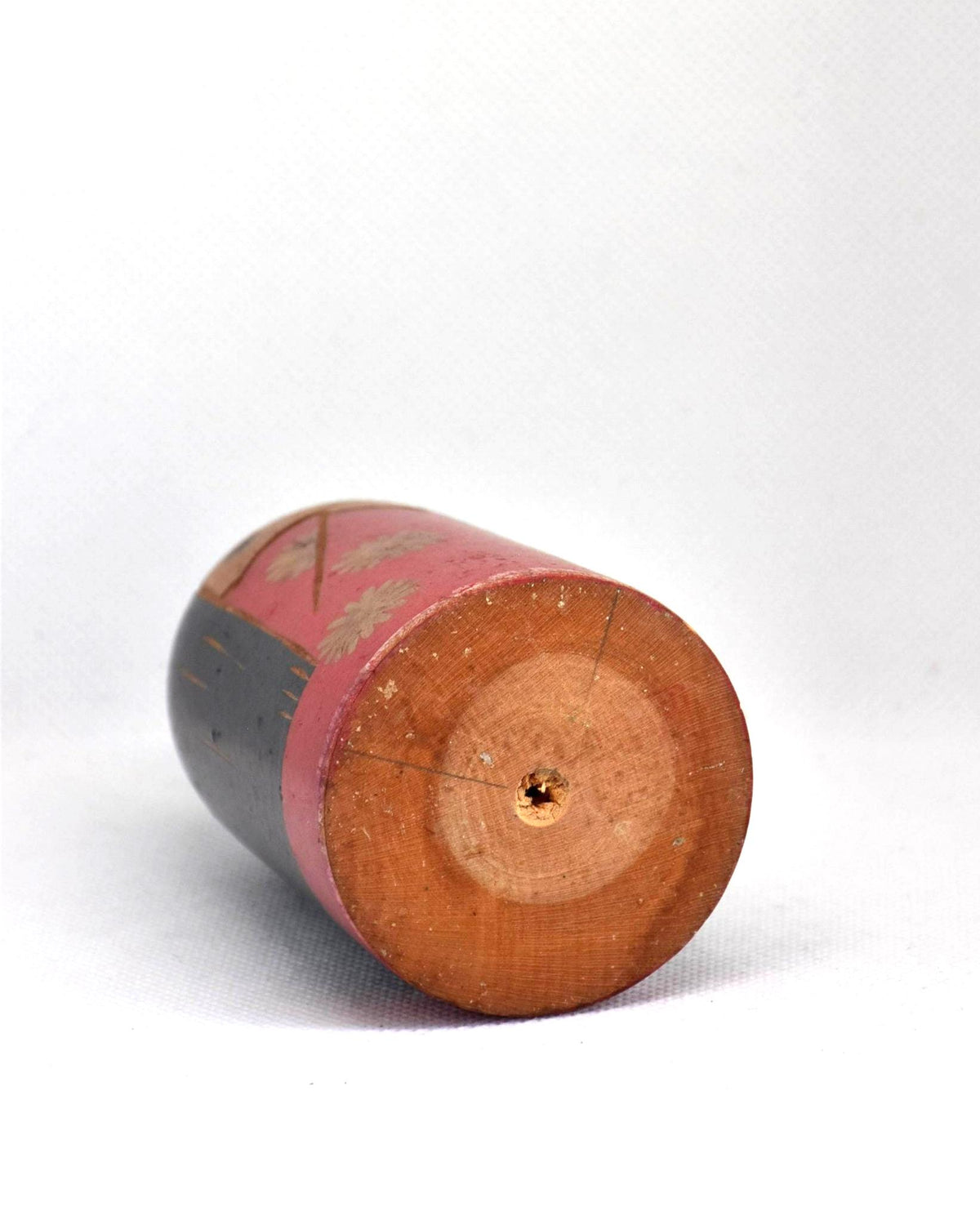 Japanese Kokeshi Doll With Black Ribbon base showing the wooden grain and center hole