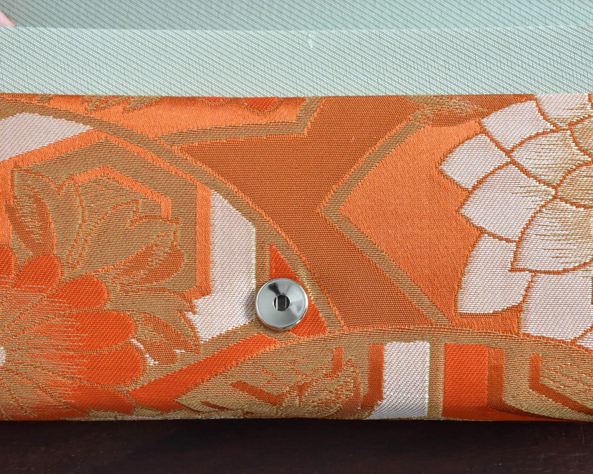 Saga Nishiki brocade clutch handbag close-up of the top edge showing the orange and gold woven textile detail.