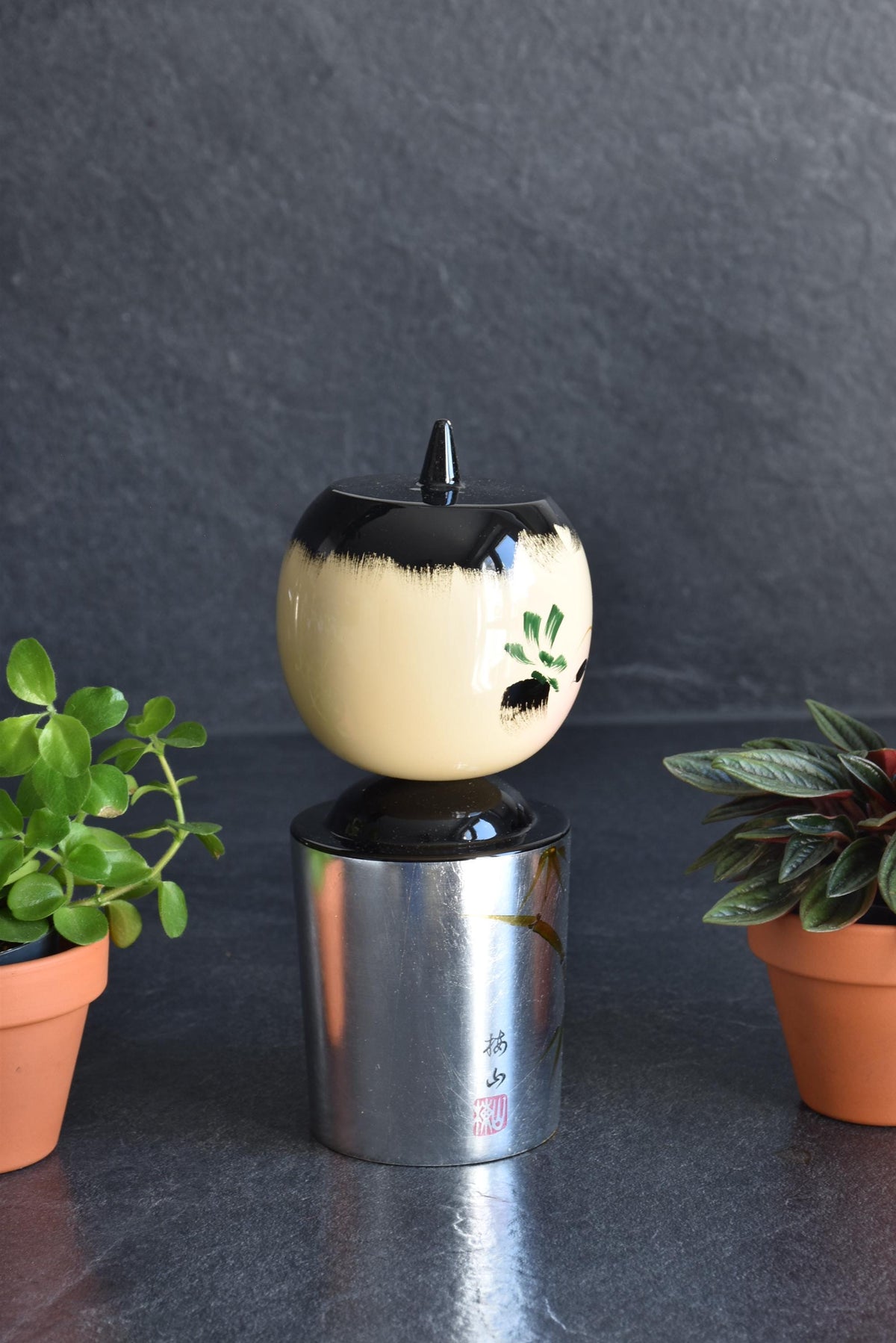 Hanawarabe kokeshi doll body showing the silver aluminum foil texture and bamboo motif