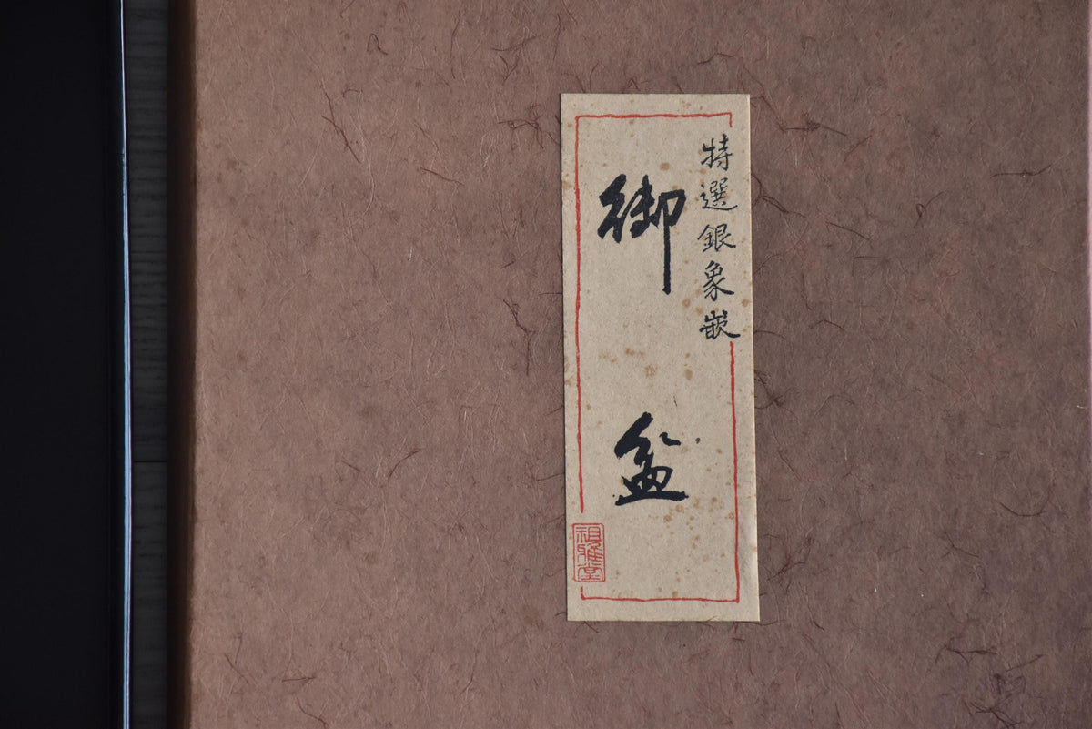 Detail view of the vertical label on the storage box with Japanese text and red artisan seal