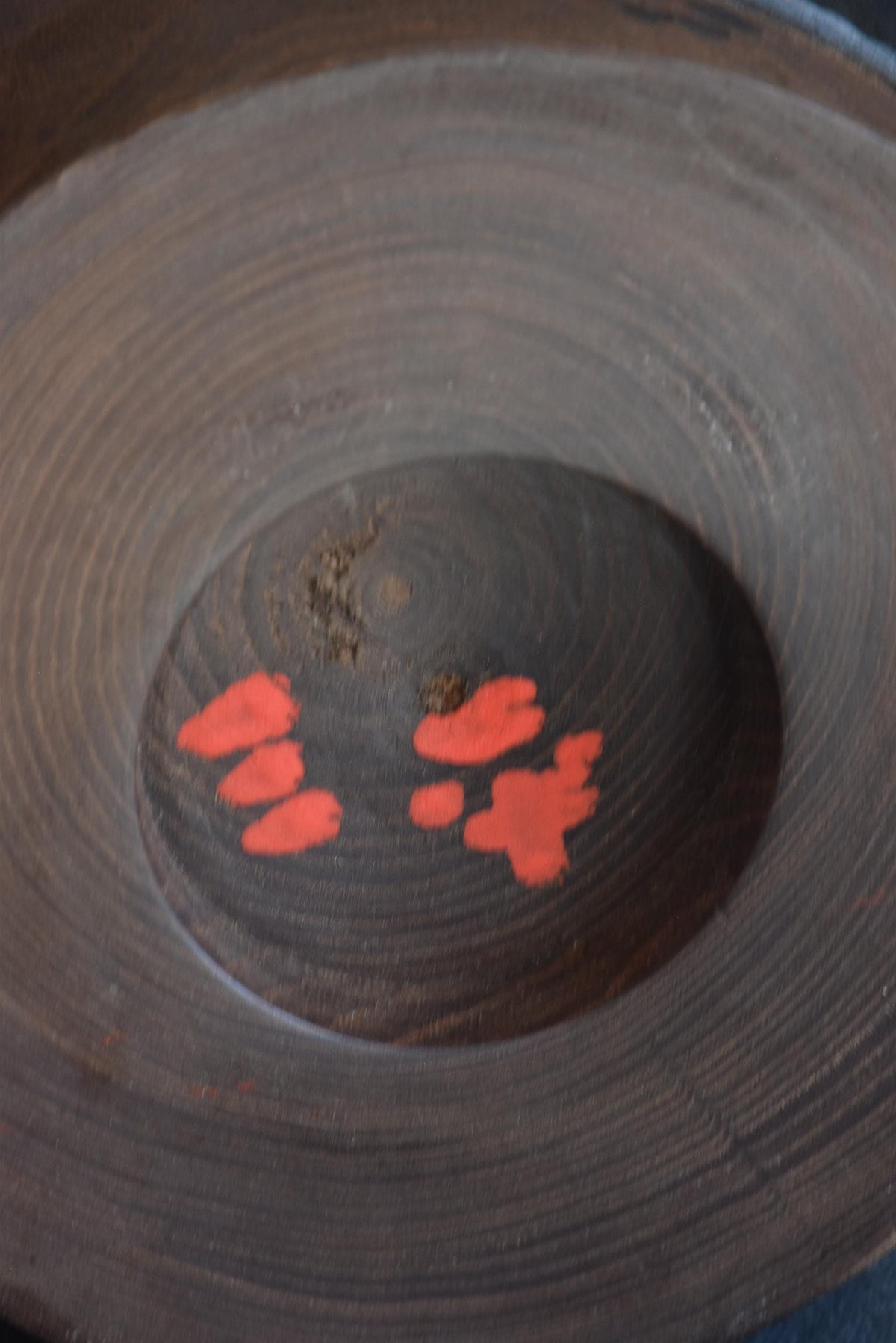 Sanpei Yamanaka kokeshi base showing artist signature in orange-red lacquer