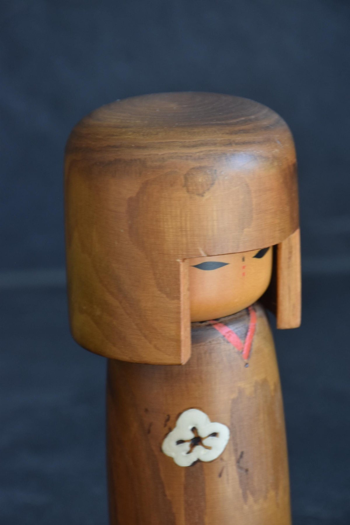 Usaburo kokeshi doll upper body close-up showing the face and painted collar detail