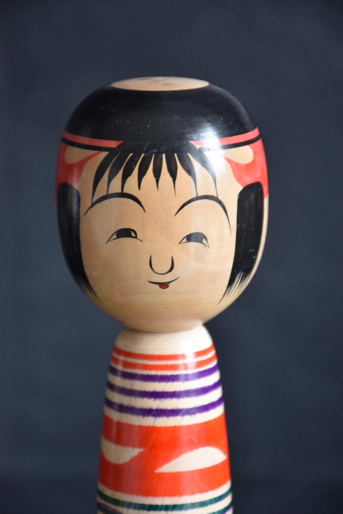 Tsuchiyu kokeshi doll angled close-up of the painted face and upper body details