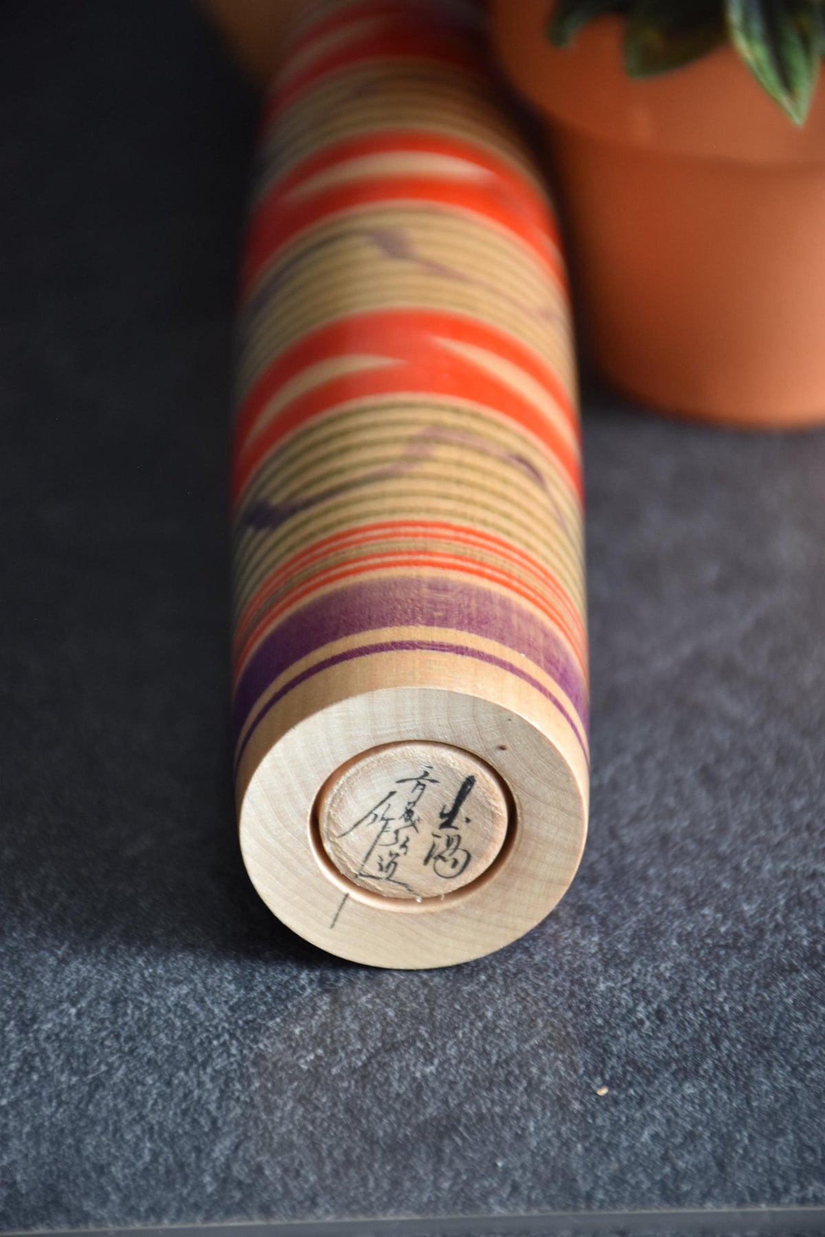 Tsuchiyu kokeshi doll base showing artisan signature hand-signed in black ink