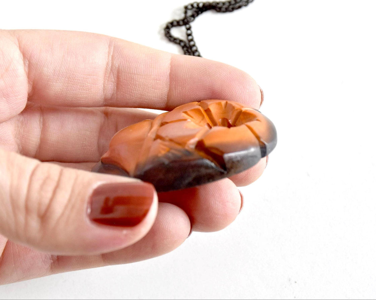 Ainu hand-carved wooden floral medallion necklace profile thickness in hand