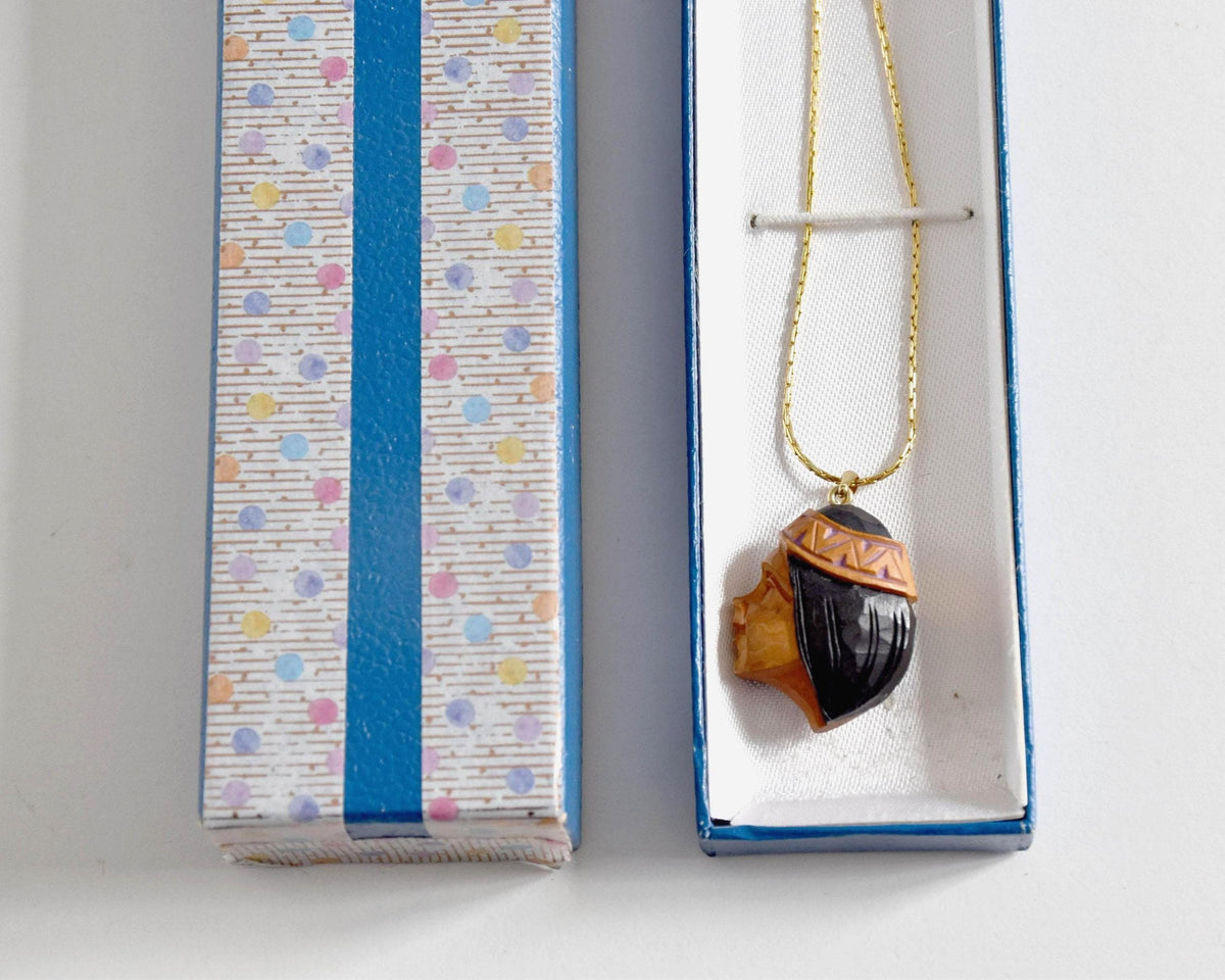 Ainu handcarved wood pendant necklace displayed in its original vintage storage box