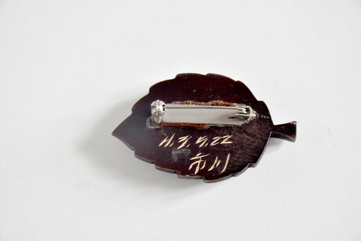 Back of Ainu leaf brooch showing metal clasp signature and 1991 date