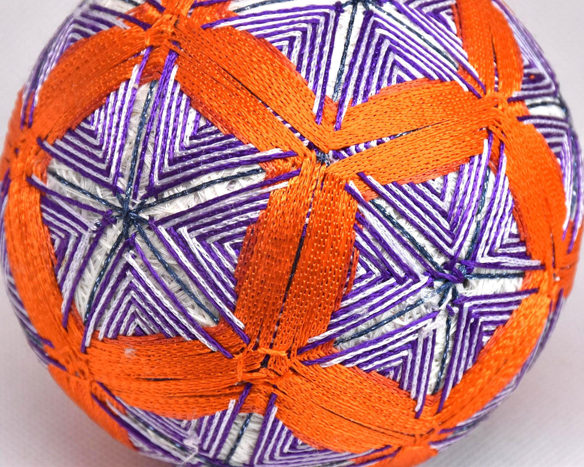 Hand-Embroidered Temari Ball Orange And Purple table scatter close up showing colourful thread stitching