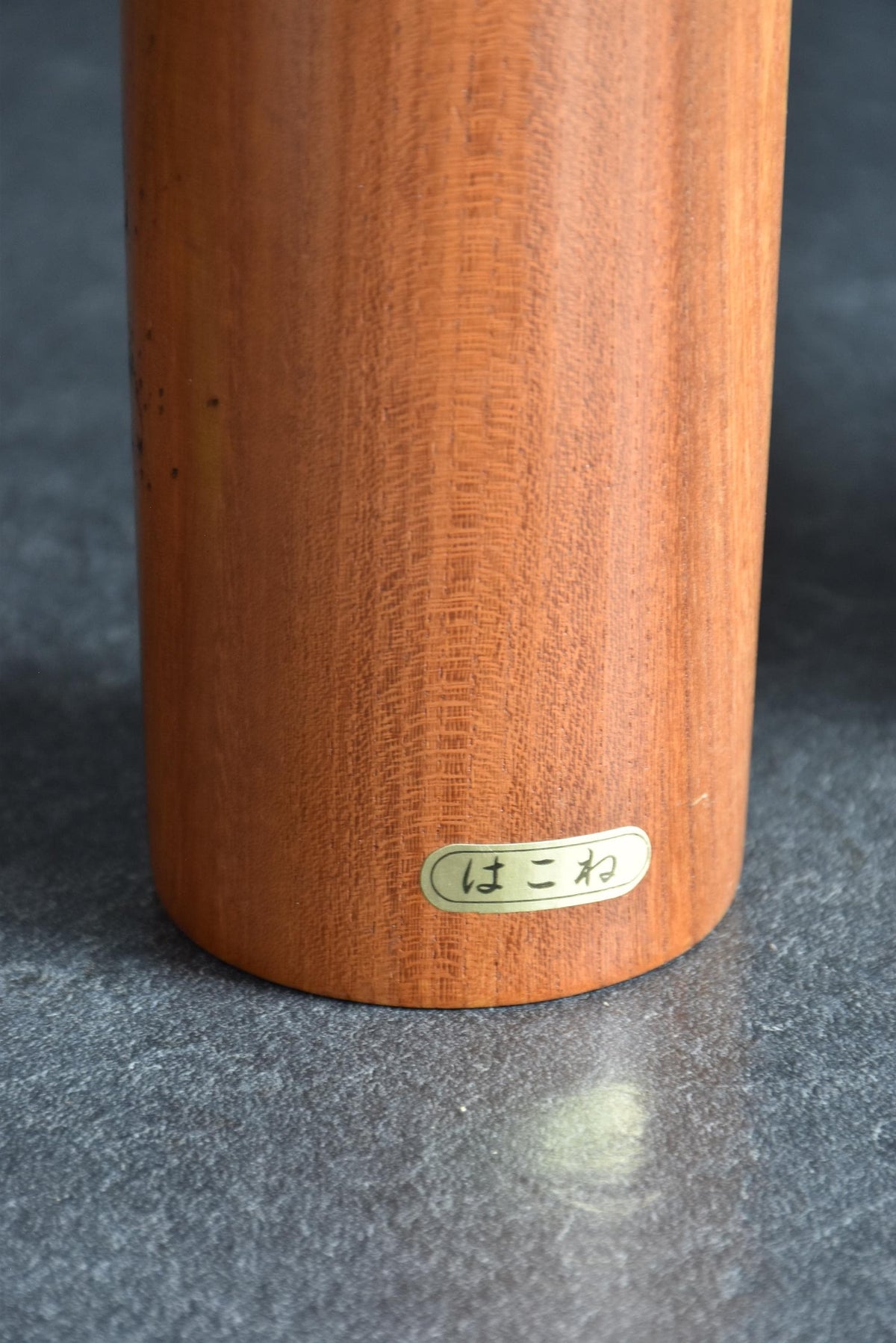 Toa Sekiguchi kokeshi doll lower body featuring a small Japanese sticker label