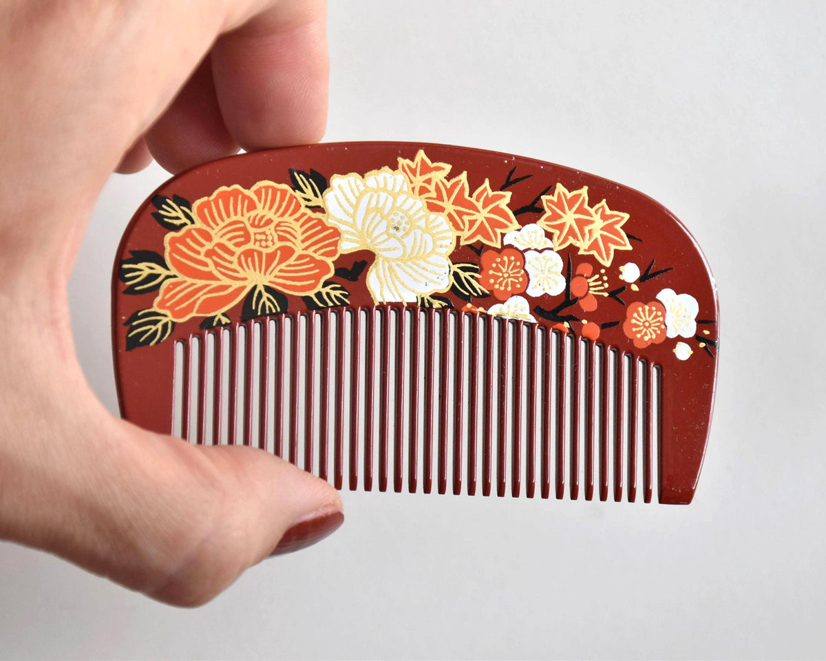 Toyama traditional hair comb close-up view displaying the detailed peony, plum blossom and maple leaf motif