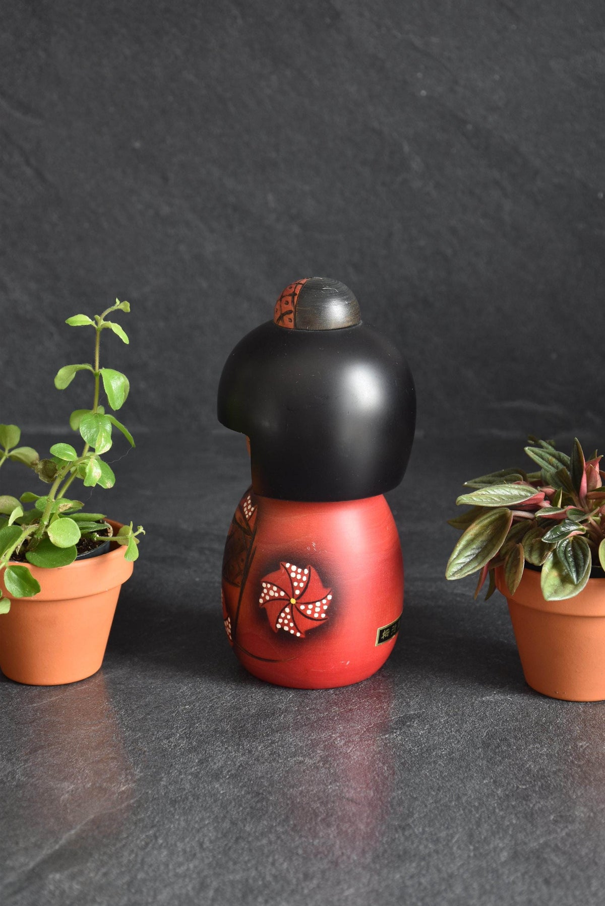 Masae Fujikawa kokeshi doll showing back of the red kimono with carved floral pattern