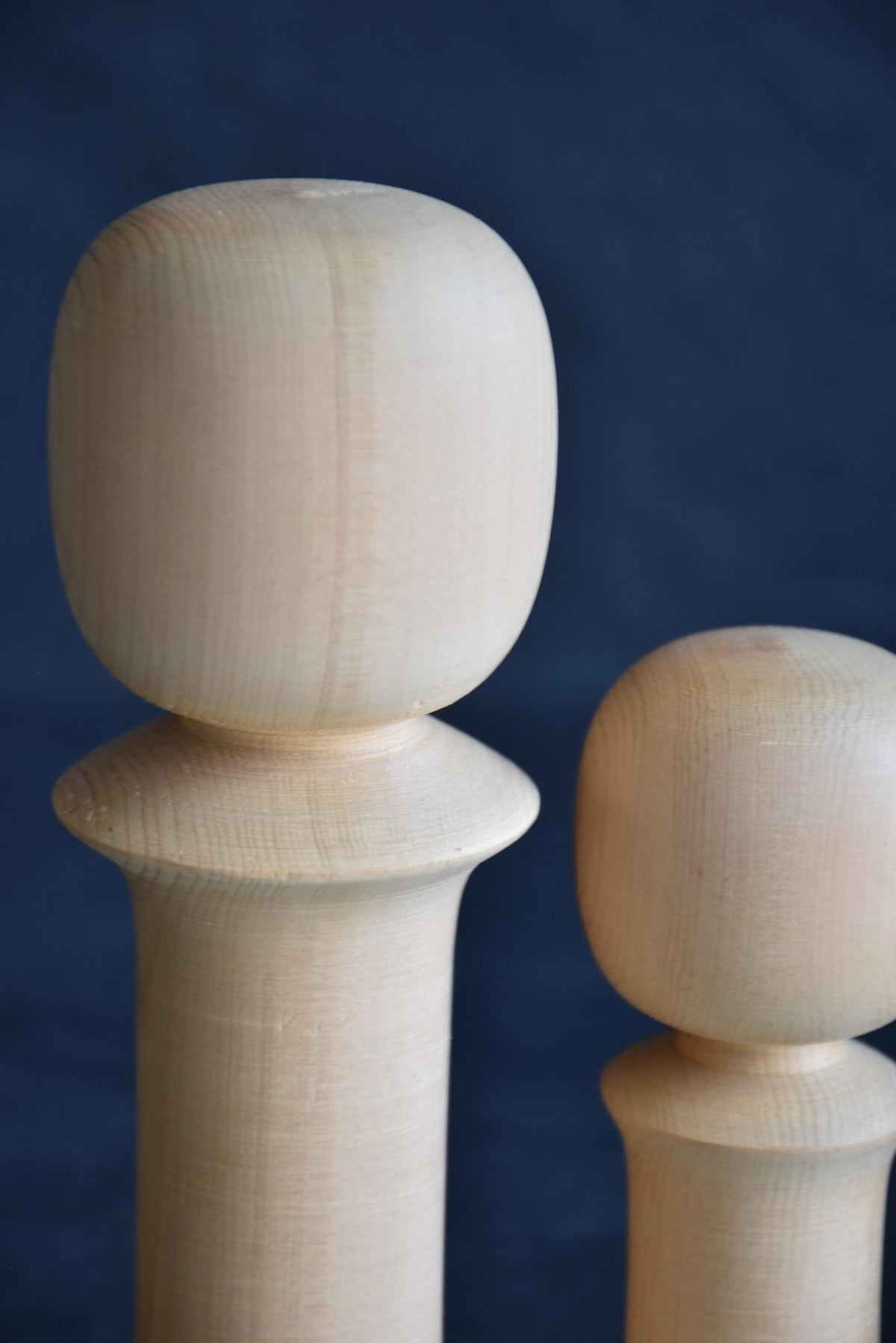 Isamu Ise kokeshi dolls close up of the smooth carved wooden head shapes.