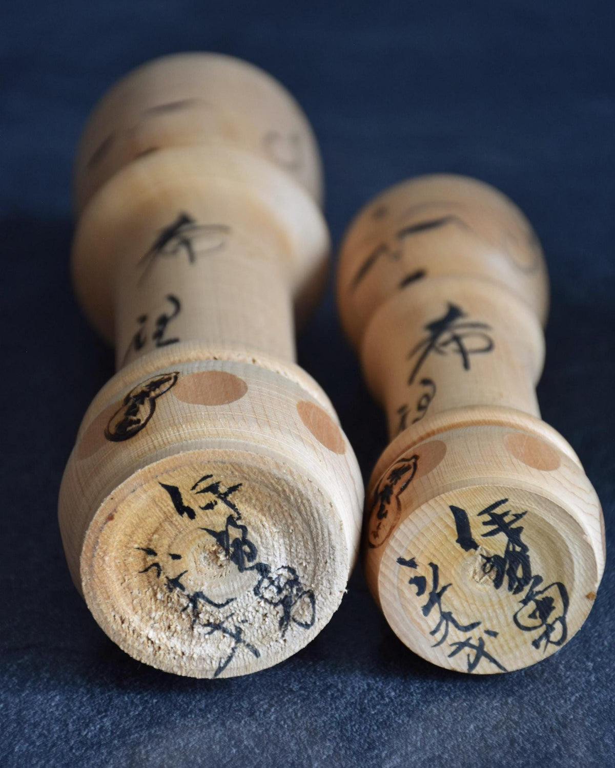 Isamu Ise kokeshi dolls base showing hand-signed maker name and age inscriptions.