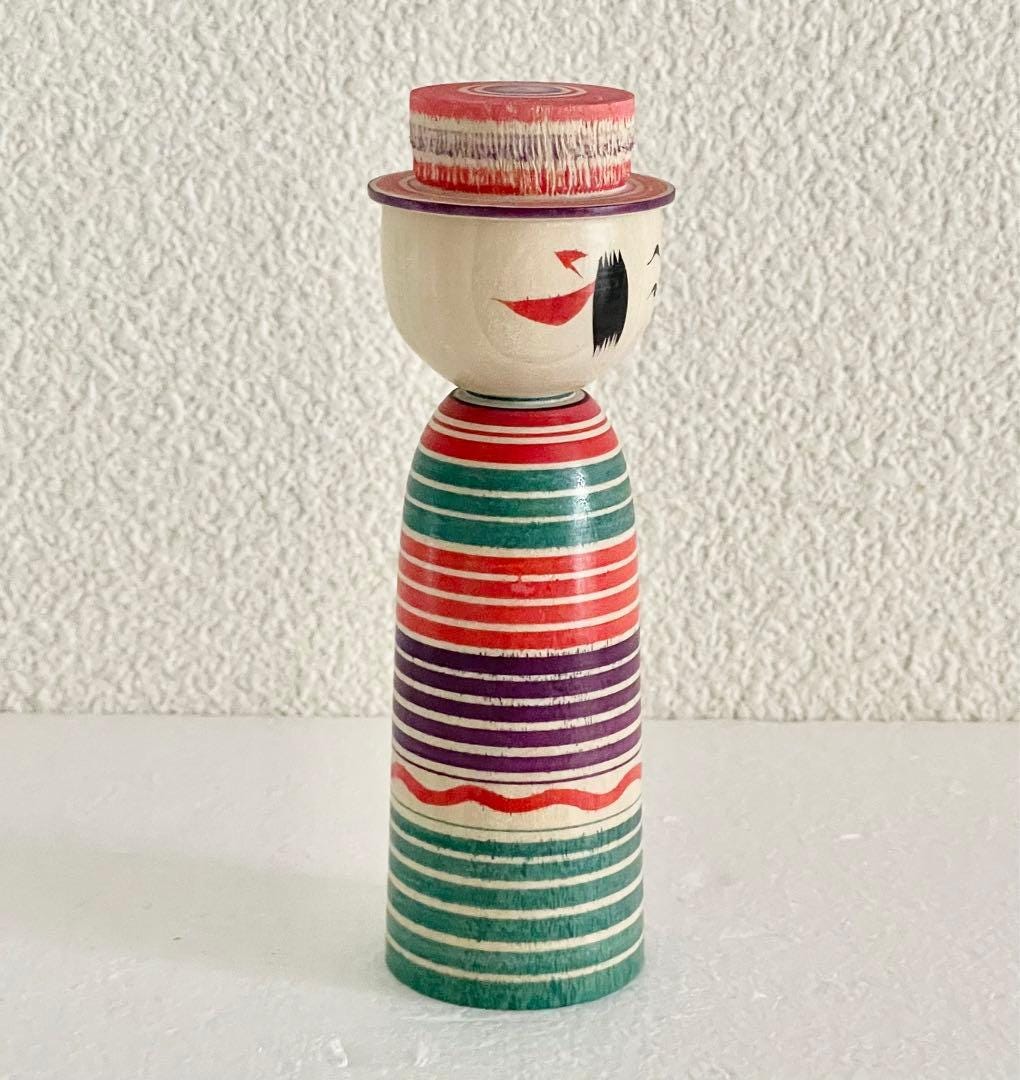 Sadayoshi Hoshi kokeshi doll viewed from the right side showing facial features and painted hair