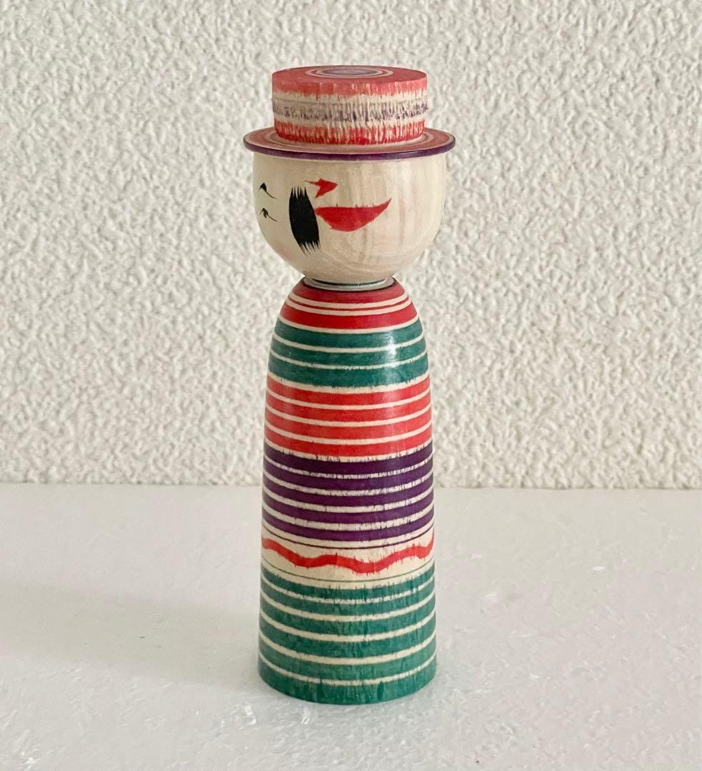 Sadayoshi Hoshi kokeshi doll viewed from the left side showing profile and hand-painted details