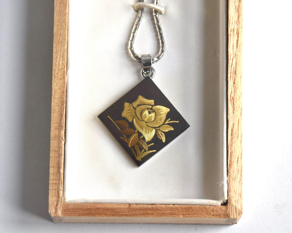 Japanese Zogan Floral Damascene Pendant Necklace positioned inside the open wooden box
