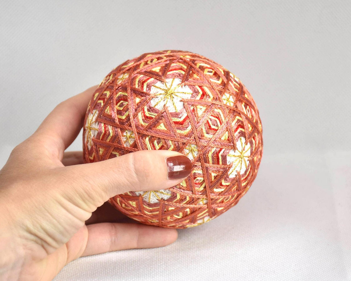 Hand-Embroidered Japanese Temari Ball Folk Art shown next to a hand for scale