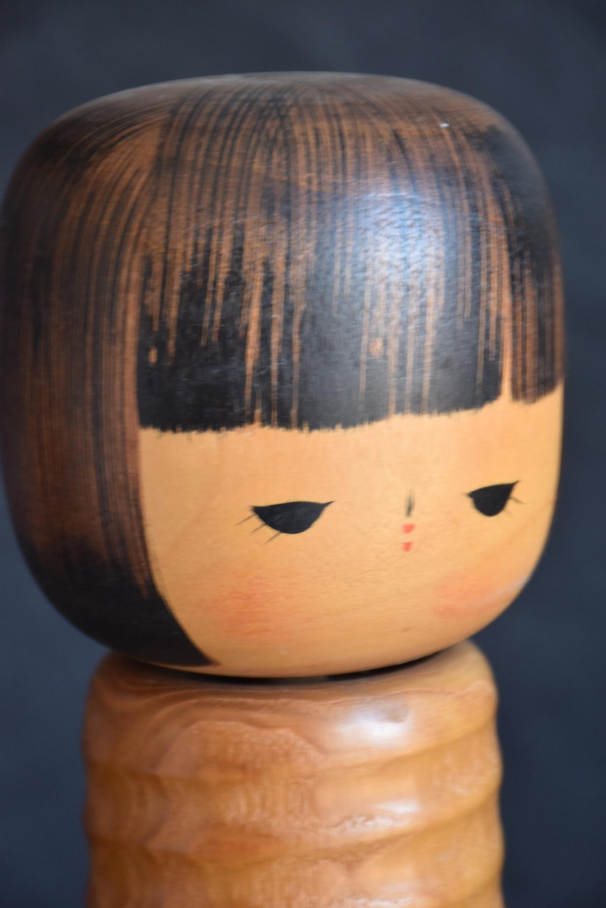 Usaburo sosaku kokeshi face detail showing painted bob haircut and features