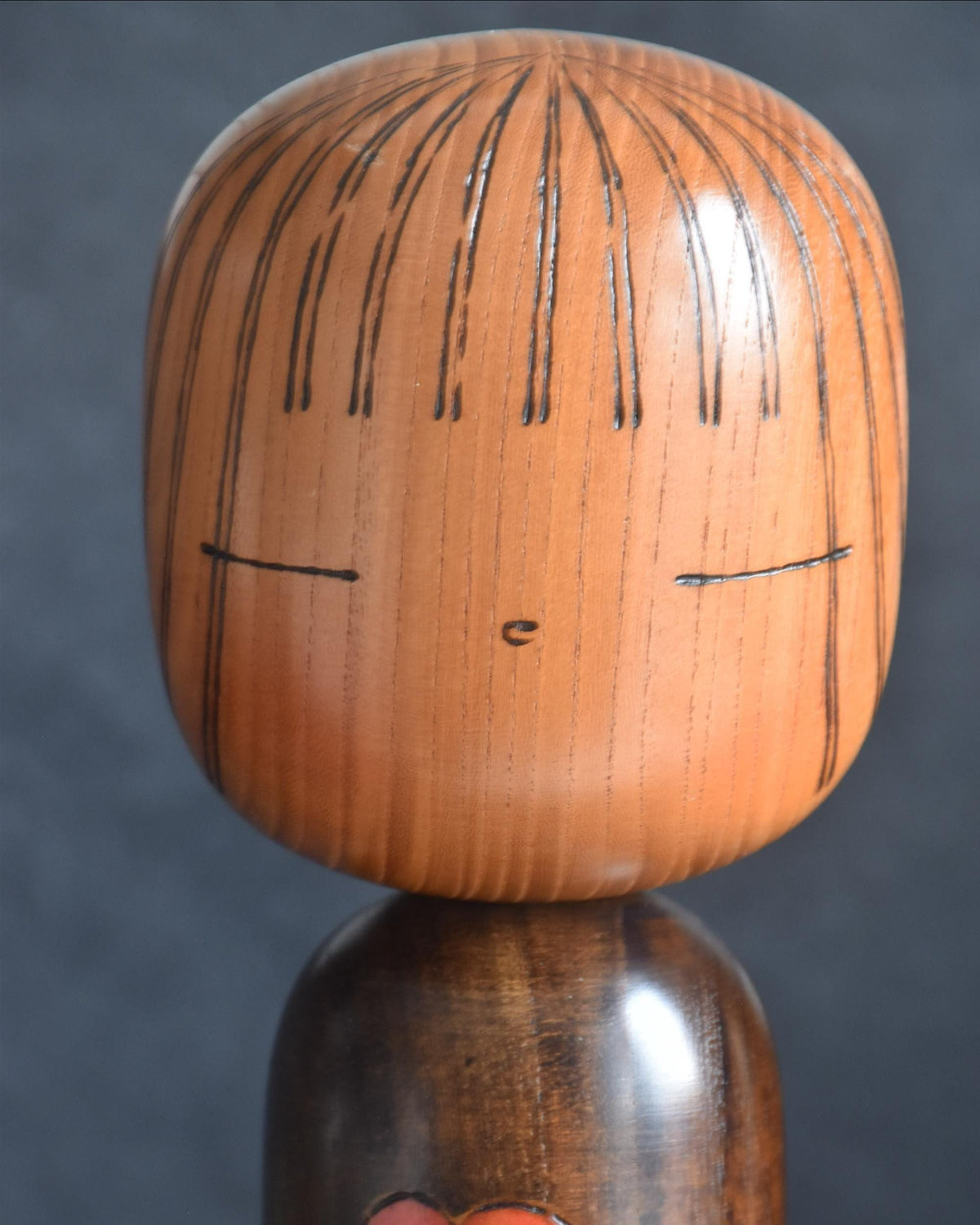 Ryozo Tsujita kokeshi doll head detail showing painted facial features and incised hair lines