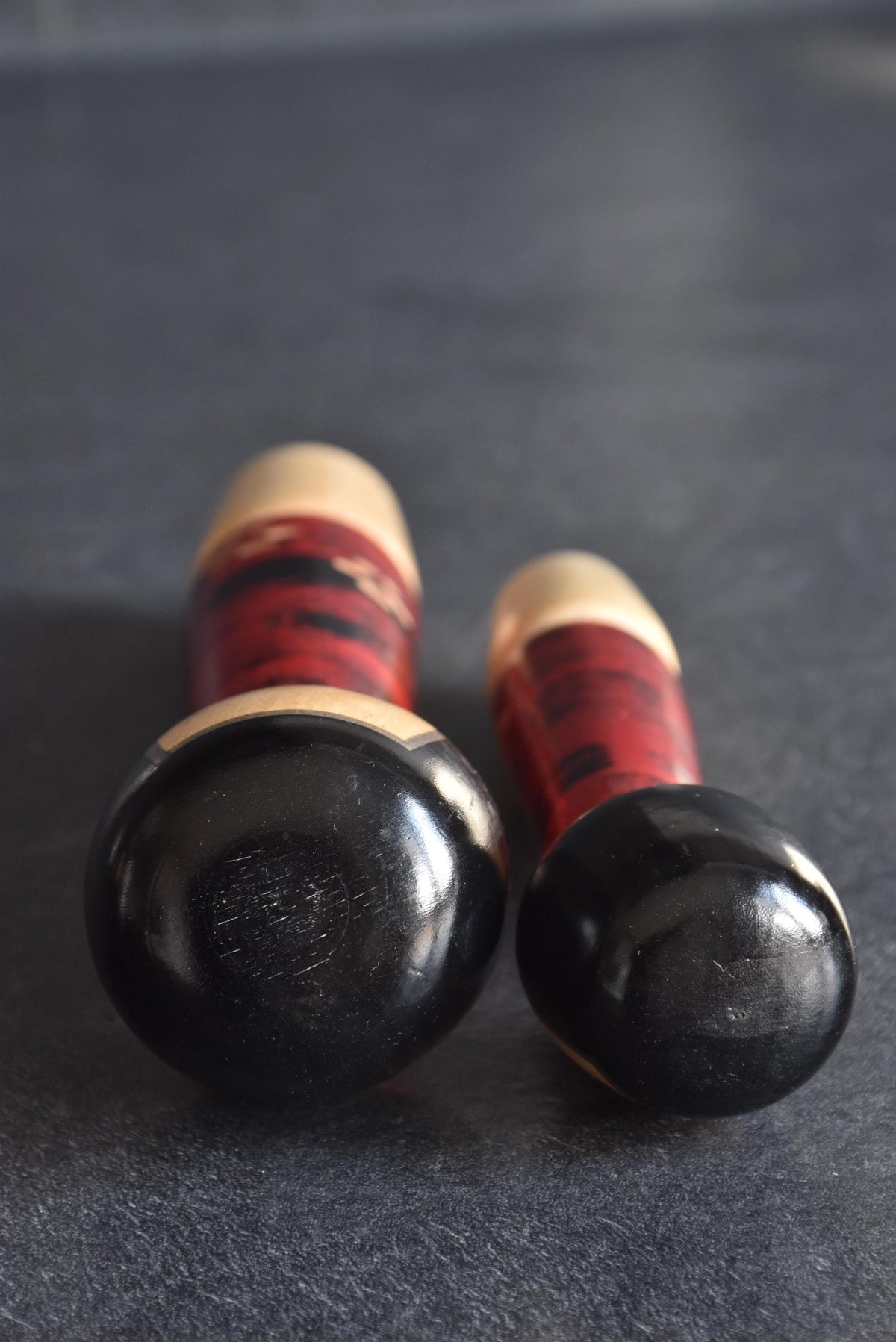 Aida Seihou kokeshi Sisters overhead view showing the hand chiseled chattering texture on the hair crowns