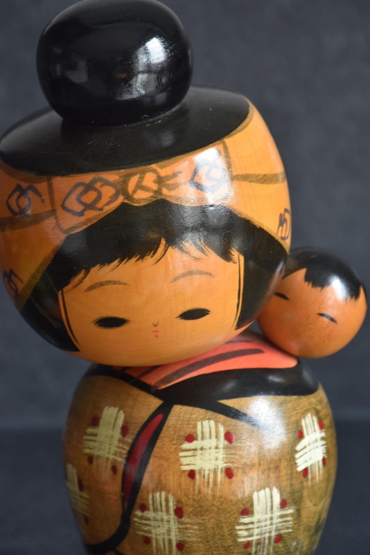 Hajime Miyashita kokeshi close up of face and child on back