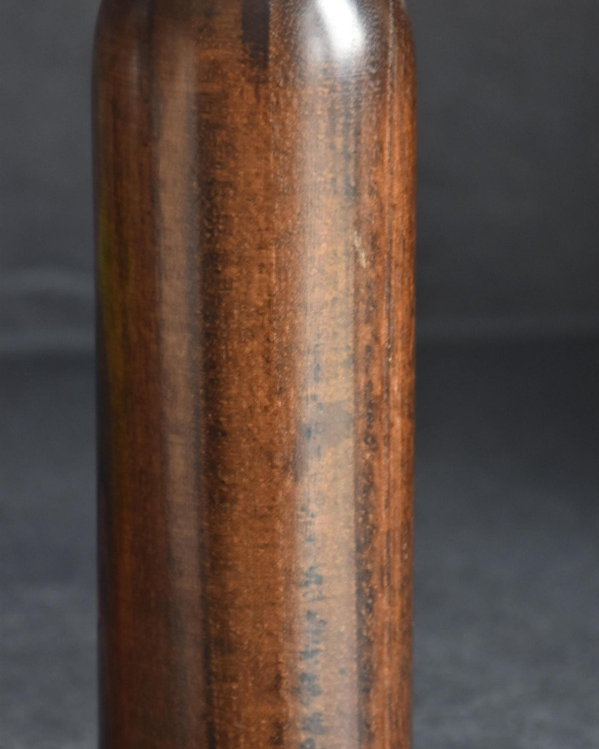 Ryozo Tsujita kokeshi doll unadorned side of the dark brown wood body showing vertical grain