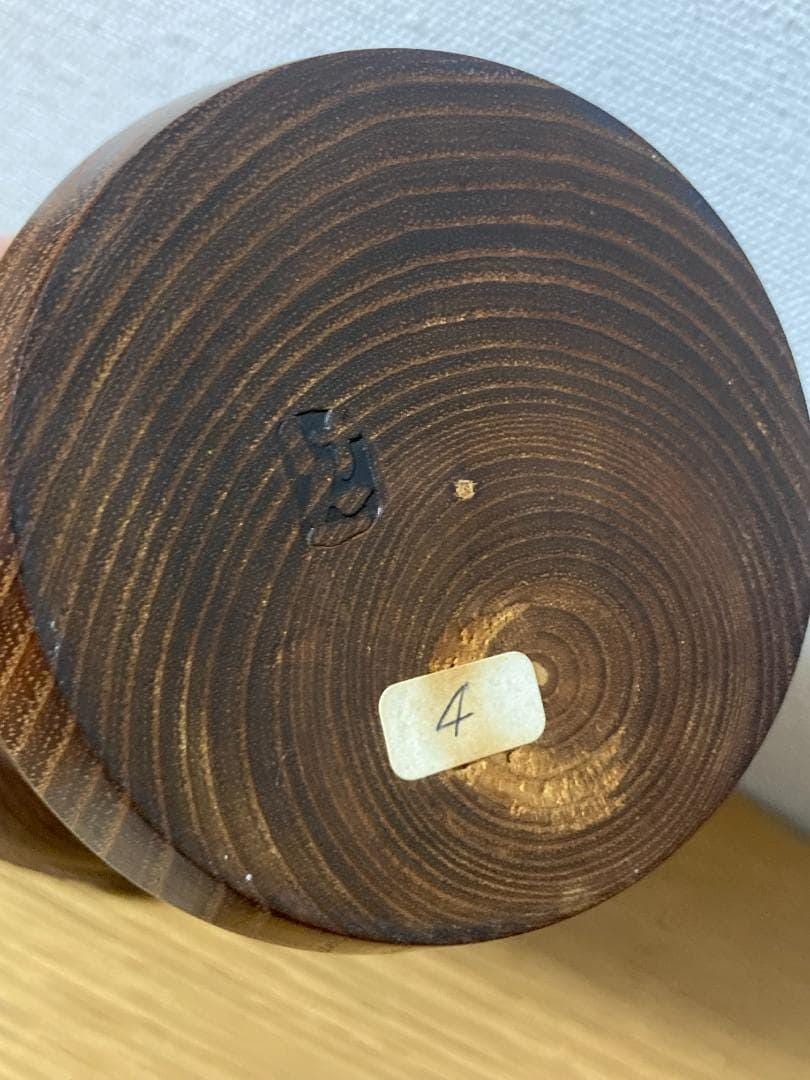 Kenichi Murakami kokeshi base showing wood grain, artisan signature stamp, and small label