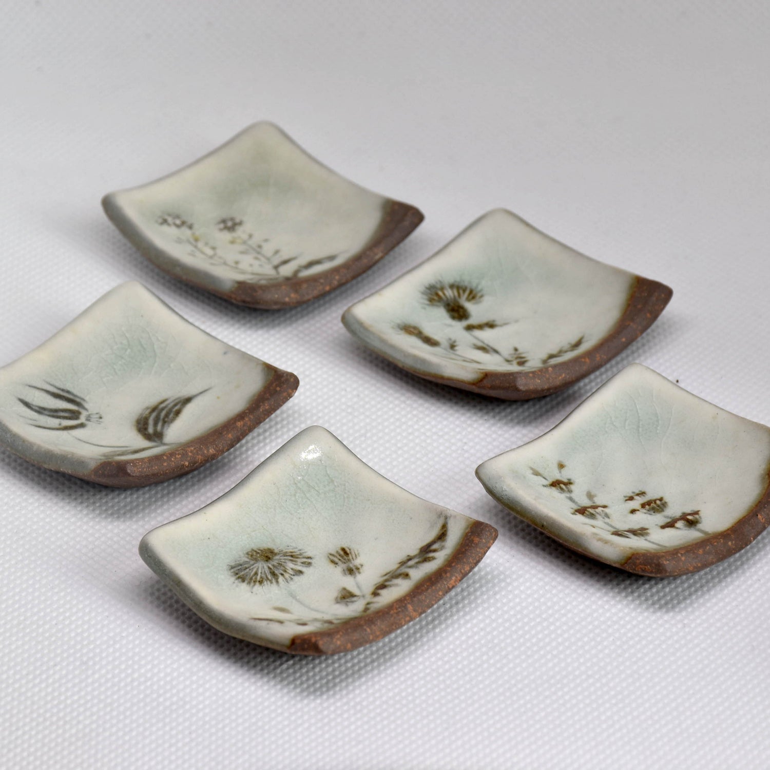 Set of artisan ceramic and wooden Hashioki chopstick rests for authentic Japanese table setting.