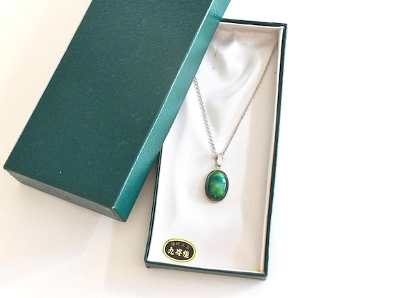 Green Oval Kutani pendant necklace resting inside its original presentation box