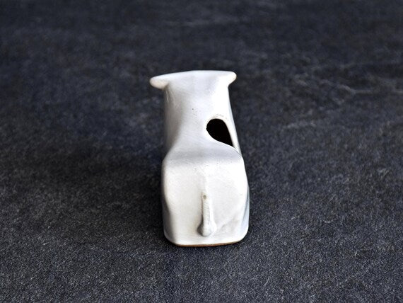 Japanese ceramic cow figurine showing back and tail detail with opening on top