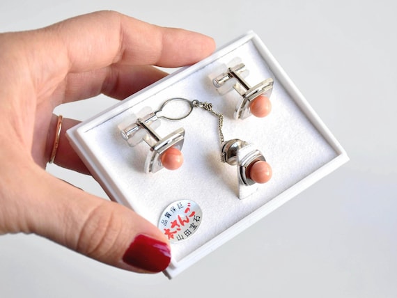 Ezaki Japanese Coral Cufflinks & Tie Pin Set featuring modernist silver-tone metal and apricot coral cabochons held in a hand