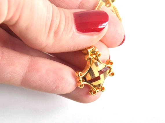 Yosegi Zaiku Star Pendant Necklace held in a hand to show scale next to fingers