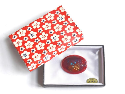 Kutani Dark Red Ceramic Brooch presented in its signature box with the decorative red floral lid positioned beside it