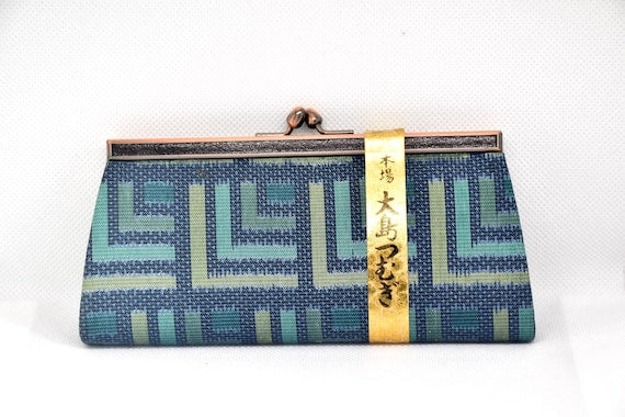 Oshima Tsumugi silk coin purse front view featuring blue and green traditional textile design