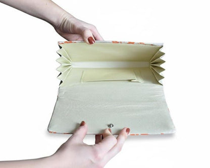 Kimono clutch interior view highlighting the fabric lining, accordion sides, and secure metal clasp